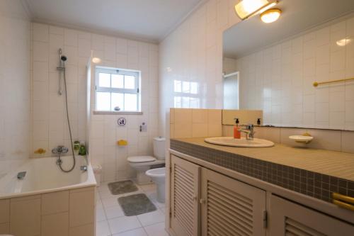 uma casa de banho com um lavatório, uma banheira e um WC. em Leiria Fatima Nazaré 3 Bedroom House em Leiria