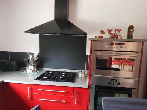 a kitchen with red cabinets and a stove top oven at L occitane in Gimont