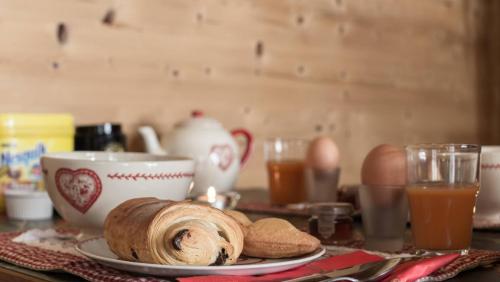 a table with a plate of bread and a cup of coffee at Ride and Breakfast in Montriond