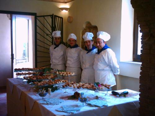 a number of people in a kitchen preparing food at Hotel Il Malandrone in Rosignano Marittimo