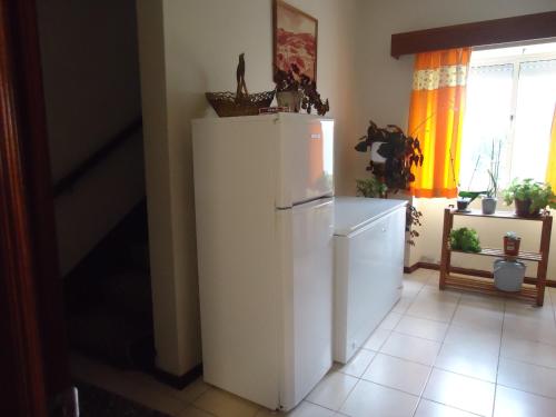 a kitchen with a white refrigerator and a window at Casa Branca in Lagoa