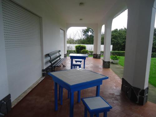 a patio with a blue table and two stools at Casa Branca in Lagoa