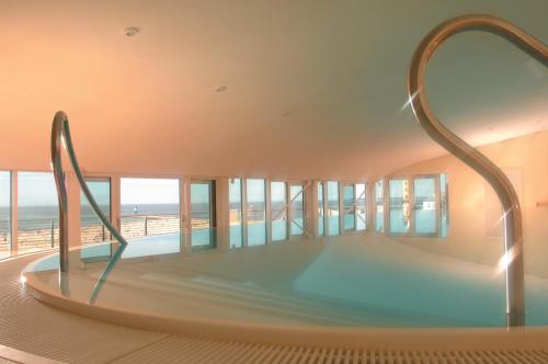 a large swimming pool in a hotel room at Strand-Hotel Hübner in Warnemünde