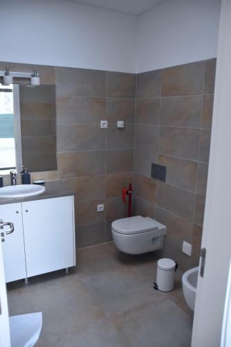 a bathroom with a toilet and a sink at Amora Villa - Vilamoura in Vilamoura