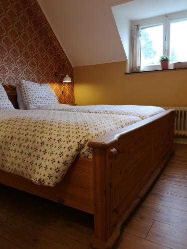 a bedroom with a large wooden bed with a window at Villa Warempel in Valkenburg