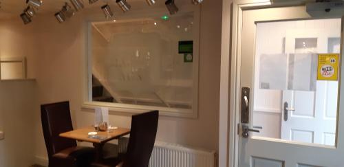 a small table with two chairs next to a door at The Masons Arms in Harrogate