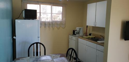 a kitchen with a white refrigerator and a table with chairs at Westernaire Motel in Mesa