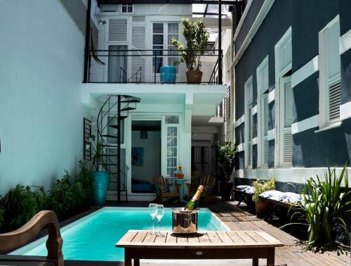 a patio with a table and a swimming pool at Casa Tuxi in Rio de Janeiro
