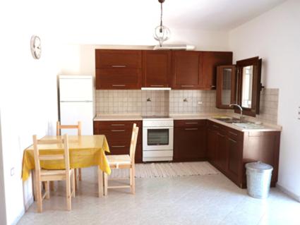 een keuken met een tafel en een tafel en stoelen bij Ariston Apartments in Serifos Chora