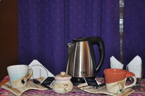 a tea kettle and cups on a table at Hospedaje Familiar Raza Mistica in Villa Unión