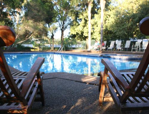2 sedie sedute accanto alla piscina di Hunter Valley Resort, Hunter Farm Adventure Centre & 4 Pines at the Farm a Pokolbin