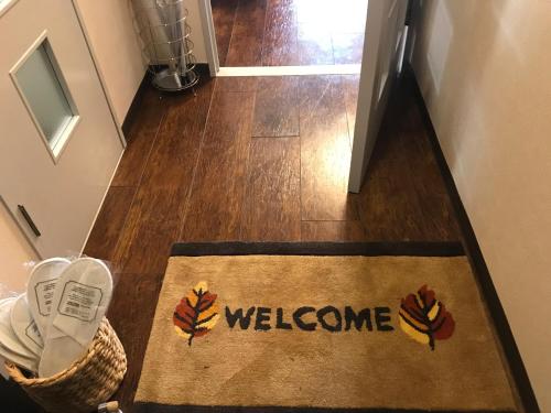 a welcome mat on the floor of a hallway at Lipelala Stay 505 in Osaka