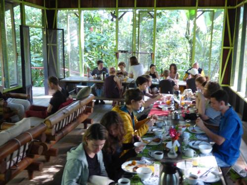 eine Gruppe von Personen, die in einem Restaurant an Tischen sitzen in der Unterkunft Yatama Rainforest Ecolodge in Sarapiquí