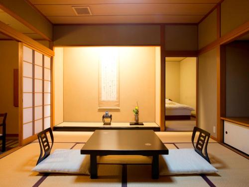 a room with a table and chairs and a bed at Matsusaki in Nomi
