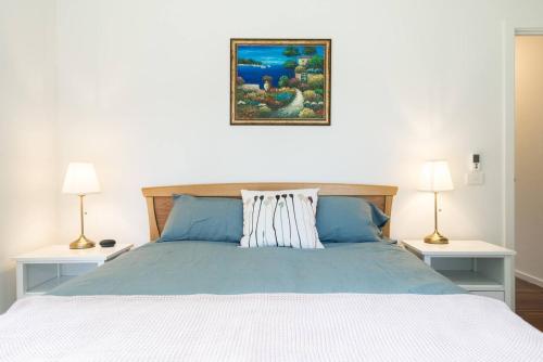 a bedroom with a large bed with two lamps at The Caretakers Cottage in Main Ridge