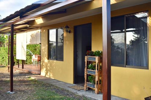 a yellow house with a front door and a porch at Dreamcatcher house in Sarchí