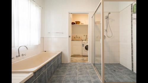 a bathroom with a bath tub and a shower at The Caretakers Cottage in Main Ridge