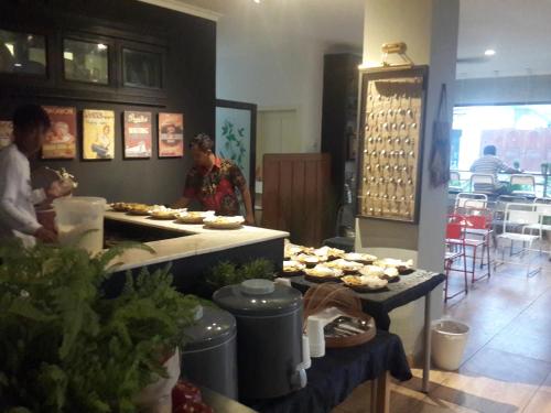 a couple of people standing in a kitchen preparing food at Manggolo Homestay Syariah in Yogyakarta