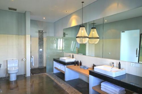 a bathroom with two sinks and a large mirror at Origin Seminyak in Seminyak