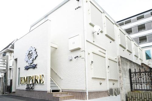 a white building with a sign on the side of it at Blue Empire Hotel in Tokyo