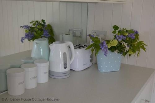 a counter with a bunch of vases and flowers on it at Tackleway Cottage in Hastings