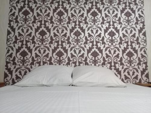 サレハルドにあるИЛНЕ Однокомнатная квартира на улице Мираの壁紙の前に白い枕が付いたベッド