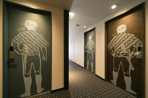 a hallway with paintings of men on the walls at Hakata Tokyu REI Hotel in Fukuoka