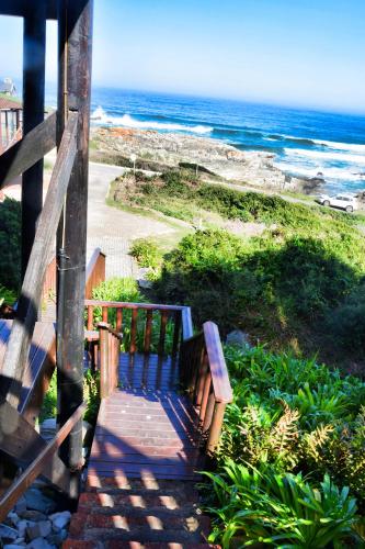 a wooden staircase leading to a beach with the ocean at Dis Al in Oubosrand