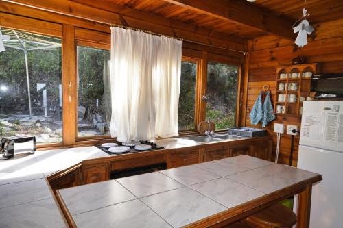 a kitchen with a counter and a refrigerator and a window at Dis Al in Oubosrand