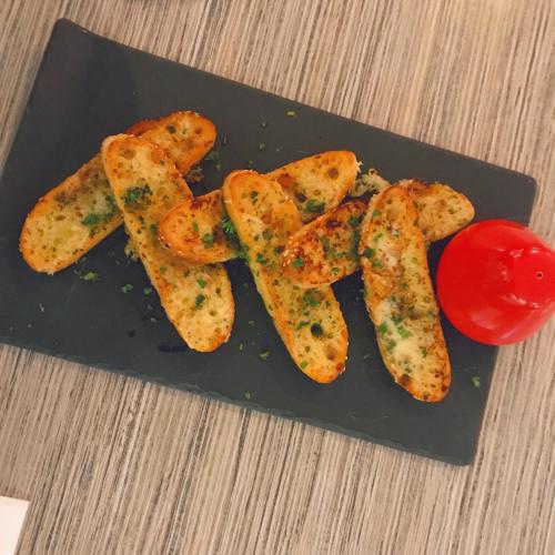 バンバリーにあるBunbury Hotel Koombana Bayのフライドポテトとトマトが乗った黒い皿