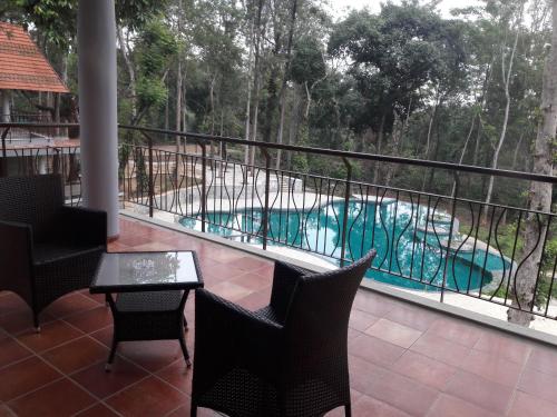 a balcony with a view of a swimming pool at The Birchwood Retreat, Madikeri in Madikeri