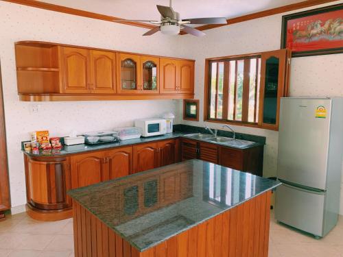 a kitchen with wooden cabinets and a white refrigerator at RiverTree House in Nong Khai