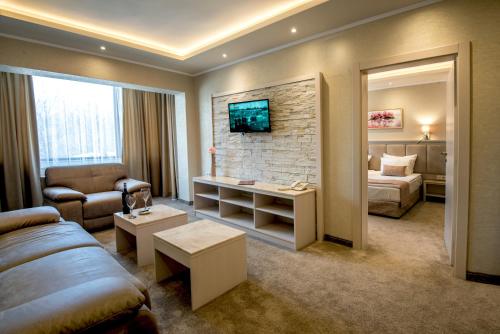 a living room with a couch and a bed in a room at Spa Hotel Armira in Starozagorski Bani