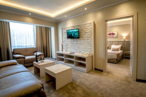 uma sala de estar com um sofá e uma cama num quarto em Spa Hotel Armira em Starozagorski Bani