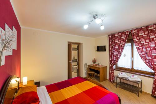 1 dormitorio con 1 cama con una manta colorida en Mandoué, en Pont-Saint-Martin