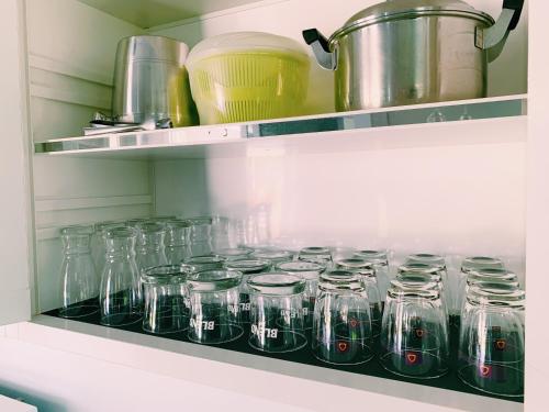 a bunch of glass jars on a shelf in a kitchen at RiverTree House in Nong Khai