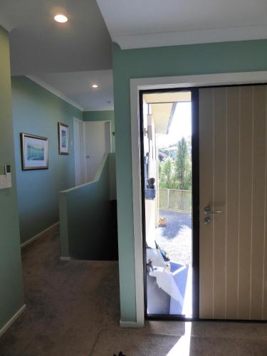 a bathroom with a door leading to a sink at Hazelwood Mapua in Mapua