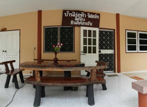 a table in a room with a sign on the wall at Baan Rai Pu Fa in Sattahip