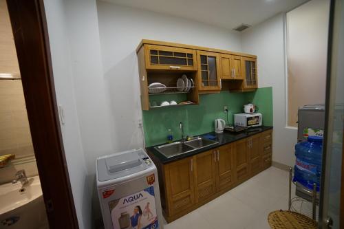 a small kitchen with wooden cabinets and a sink at Thanh Xuan Hotel in Vung Tau