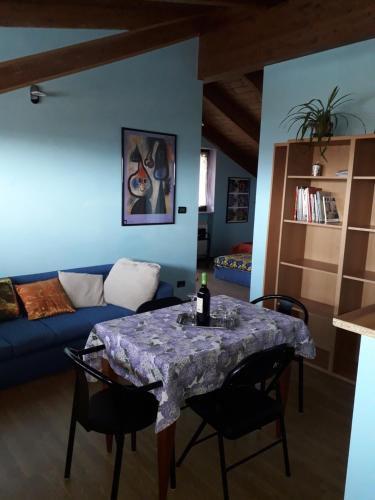- un salon avec une table et un canapé bleu dans l'établissement Appartamento LUCE, à Volpiano