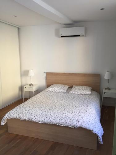 une chambre avec un grand lit avec deux tables de nuit dans l'établissement 15 rue du général carbuccia Ap, à Bastia