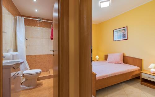 een badkamer met een bed, een toilet en een douche bij Apartmani Kažun - App1 in Fažana