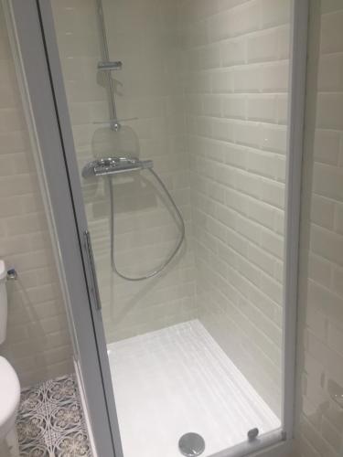 une douche avec une porte vitrée dans une salle de bain dans l'établissement 15 rue du général carbuccia Ap, à Bastia