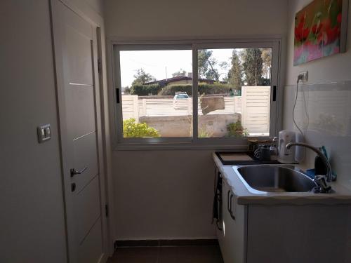 a kitchen with a sink and a window at Dead Sea Desert's Edge in Arad