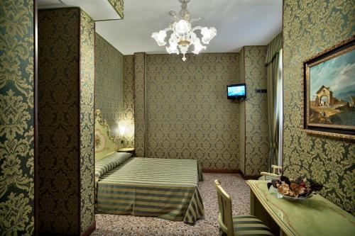 Habitación de hotel con cama y lámpara de araña. en Hotel Al Malcanton, en Venecia