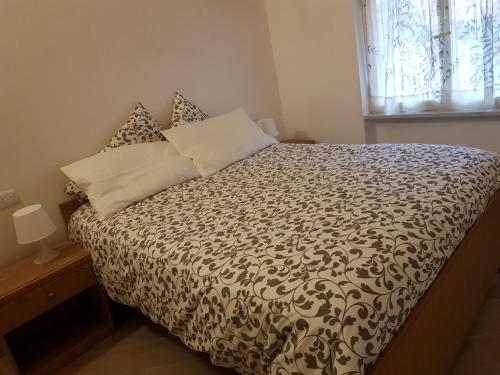Schlafzimmer mit einem Bett mit einer schwarzen und weißen Bettdecke in der Unterkunft IL MARMO (CITRA 011017-LT-0069) in Levanto