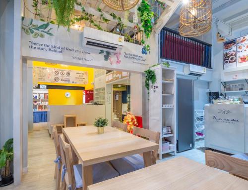 Kinnon Deluxe Hostel Coworking Cafe في بانكوك: غرفة طعام مع طاولة وكراسي