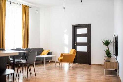een woonkamer met een tafel en stoelen en een deur bij WONDER CRACOW in Krakau