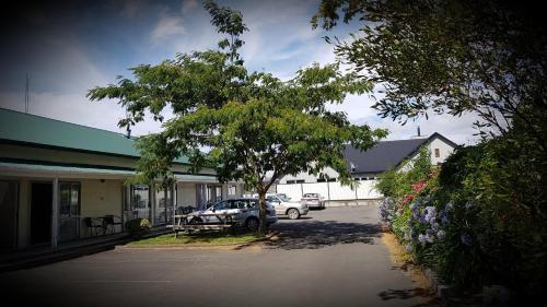 a car parked in a parking lot next to a building at Chanel Court Motel in Masterton