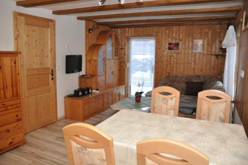 sala de estar con mesa, sillas y sofá en Ferienhaus Neubert, en Wolkenstein